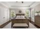 Serene main bedroom with a tray ceiling, hardwood floors, plantation shutters, and a cozy sitting area at 5330 Lake Redwine Nw Cv, Acworth, GA 30101