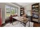 Well-lit home office features a large window, custom shelving, hardwood floors, and a comfortable workspace at 5330 Lake Redwine Nw Cv, Acworth, GA 30101