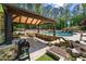 Beautiful outdoor kitchen and bar area with a timber framed pergola, stone counters, and access to a large swimming pool at 5330 Lake Redwine Nw Cv, Acworth, GA 30101
