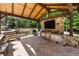 Outdoor kitchen area under a timber-framed pergola, featuring stone counters, stainless steel appliances, and a tv at 5330 Lake Redwine Nw Cv, Acworth, GA 30101