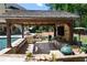 Inviting outdoor kitchen under a timber-framed pergola, with stone counters, bar seating, and professional grill at 5330 Lake Redwine Nw Cv, Acworth, GA 30101