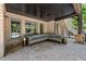 Covered outdoor living space with a large sectional sofa and view of the landscaped backyard at 5330 Lake Redwine Nw Cv, Acworth, GA 30101