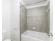 Clean bathroom with shower/tub combo and gray tile surround at 970 Samples Nw Ln, Atlanta, GA 30318