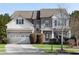 Two-story brick and shingle home with a three-car garage and landscaped yard at 2217 Spring Stone Ct, Buford, GA 30519