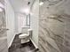 Updated bathroom with dark tile floors and marble-look walls at 1394 Yates Ave, Austell, GA 30106