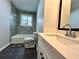Updated bathroom with gray tile, white vanity, and a bathtub at 1394 Yates Ave, Austell, GA 30106