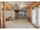 Partially unfinished basement featuring wood framing, concrete floors, and a walkout door at 4595 Carriage Walk Ln, Cumming, GA 30040