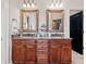 Bathroom featuring double vanity sinks with granite countertops and framed mirrors, adding a touch of elegance at 4595 Carriage Walk Ln, Cumming, GA 30040