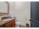 Well-lit powder room featuring a granite countertop and decorative mirror at 4595 Carriage Walk Ln, Cumming, GA 30040