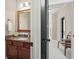 Bathroom with a granite counter and a wooden framed mirror, with views into the hallway at 4595 Carriage Walk Ln, Cumming, GA 30040