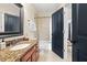 Bathroom with a granite counter, tiled walls and floors, and a peek into the hallway at 4595 Carriage Walk Ln, Cumming, GA 30040