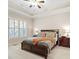 Comfortable bedroom featuring a tray ceiling, plantation shutters, and a plush bed, perfect for relaxation at 4595 Carriage Walk Ln, Cumming, GA 30040