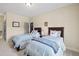 Bedroom with two matching beds, neutral walls and carpet, black doors, and small decor on the walls at 4595 Carriage Walk Ln, Cumming, GA 30040