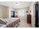 Bedroom with neutral walls and carpet, window shutters, a bed with pillows, and a black door at 4595 Carriage Walk Ln, Cumming, GA 30040