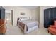 Bedroom with neutral walls and carpet, black doors, a bed with pillows, and an adjacent sitting chair at 4595 Carriage Walk Ln, Cumming, GA 30040