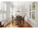 Sunlit dining room featuring wood floors and windows with plantation shutters at 4595 Carriage Walk Ln, Cumming, GA 30040