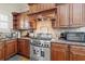Kitchen featuring stainless steel range, granite countertops and stained wood cabinetry at 4595 Carriage Walk Ln, Cumming, GA 30040