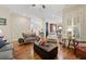 Open-concept living room with hardwood floors and seamless flow to the dining area at 4595 Carriage Walk Ln, Cumming, GA 30040