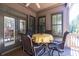 Covered outdoor seating area with a yellow tablecloth and a view to the backyard and wooded area at 4595 Carriage Walk Ln, Cumming, GA 30040