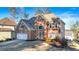 Brick two-story house with a white garage door and landscaping at 2151 Lake Haven Way, Suwanee, GA 30024