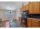 Eat-in kitchen with wood cabinets, black countertops, and stainless steel appliances at 954 Josie Ct, Lawrenceville, GA 30045