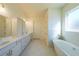 Elegant bathroom with double vanity, marble tile and soaking tub at 5450 Crow Dr, Cumming, GA 30041