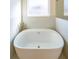 Freestanding bathtub with marble tile surround and a window at 5450 Crow Dr, Cumming, GA 30041