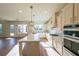 Open kitchen with island, stainless steel appliances, and hardwood floors at 5450 Crow Dr, Cumming, GA 30041