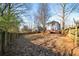 Backyard with grass, trees, wood fence and a view of the home and back deck at 110 Bowen Sw Cir, Atlanta, GA 30315