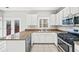 Well lit kitchen with stone countertops, white cabinets, stainless steel oven and access to outdoor patio at 110 Bowen Sw Cir, Atlanta, GA 30315
