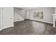 Open-concept living room boasts new flooring, a staircase, and a sunny front window at 110 Bowen Sw Cir, Atlanta, GA 30315