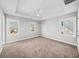 Spacious main bedroom featuring tray ceilings, three windows, and neutral carpeting at 110 Bowen Sw Cir, Atlanta, GA 30315