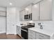 Modern kitchen with gray cabinets, white quartz countertops and stainless steel appliances at 509 Elkwood Ln, Mcdonough, GA 30252