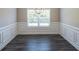 Bright dining room features elegant wainscoting and dark grey luxury vinyl plank flooring at 115 Oakdale Way, Temple, GA 30179