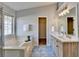 Elegant bathroom with dual vanity, large mirror, and a relaxing bathtub at 175 Paris Dr, Lawrenceville, GA 30043