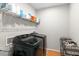 Bright laundry room with washer, dryer, and ample shelving at 580 Grimsby Ct, Suwanee, GA 30024