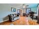 Living room with hardwood floors, brown couch, and grand piano at 461 Trabert Nw Ave, Atlanta, GA 30309