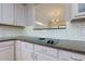 Kitchen boasts granite counters, white cabinets, and a cooktop at 991 Greenwood Ne Ave, Atlanta, GA 30306