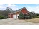 Three-car garage with brick exterior and landscaping at 209 Candice Ct, Hampton, GA 30228