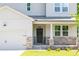 Charming home featuring a welcoming front porch, stone accents, and a two-car garage at 307 Willam Gossett Dr, Canton, GA 30114