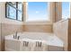 Relaxing bathroom with a soaking tub and a window at 1446 Auburn Glen Rd, Dacula, GA 30019
