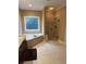 Bathroom featuring a soaking tub, glass shower, dark cabinets, and neutral tile at 1520 Vassar Ave, College Park, GA 30337