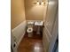 Bathroom with wood flooring, pedestal sink, wainscoting, and modern light fixture at 1520 Vassar Ave, College Park, GA 30337