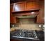 Close up of a stainless steel gas range with custom vent hood and granite countertops in kitchen at 1520 Vassar Ave, College Park, GA 30337