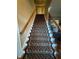 Carpeted staircase with wooden handrail leads to the upper level at 1520 Vassar Ave, College Park, GA 30337