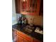 Wet bar with dark wood cabinets, decorative hardware, and a stainless steel sink at 1520 Vassar Ave, College Park, GA 30337