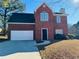 Brick two-story house with a white garage door and landscaping at 2919 Riverwalk Cv, Decatur, GA 30034