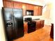 Well-equipped kitchen with black appliances and ample wood cabinetry at 307 Creek Manor Way, Suwanee, GA 30024