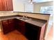 Kitchen boasts dark wood cabinets, granite countertops, and a double sink at 307 Creek Manor Way, Suwanee, GA 30024