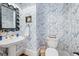 Powder room with pedestal sink, blue floral wallpaper and decorative mirror at 3998 St Georges Ct, Duluth, GA 30096